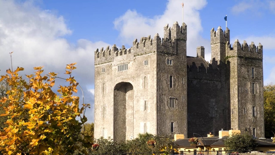 Bunratty Castle rising above autumn foliage in County Clare, one of Ireland’s best-preserved medieval tower houses.