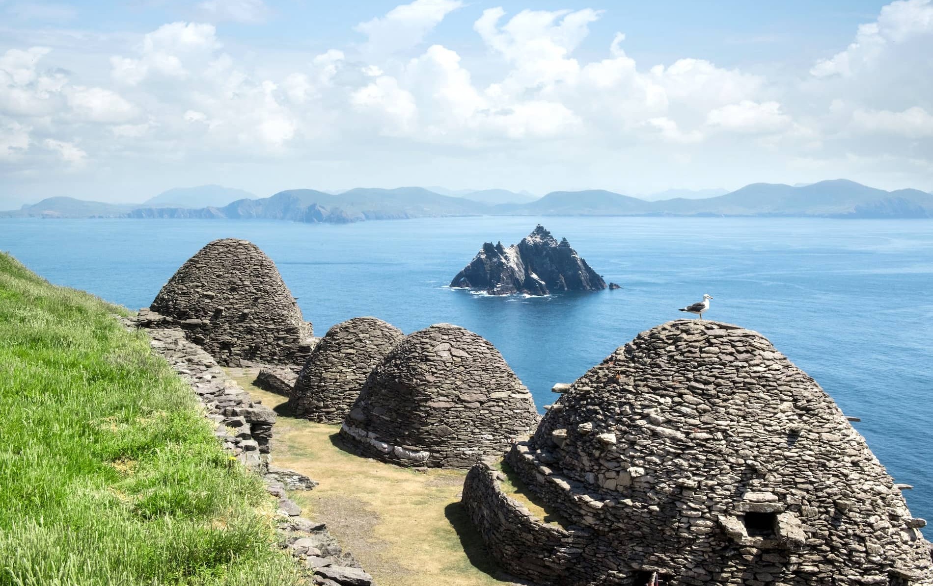 Stone beehive huts overlooking Skellig Michael and the Atlantic Ocean off the coast of County Kerry.