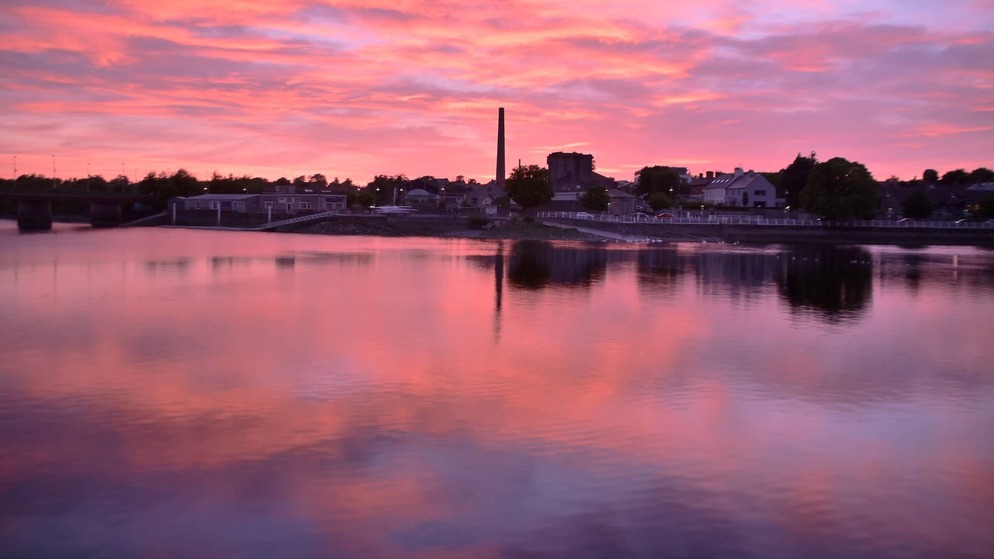 Sunset over the River Shannon at O’Callaghan Strand in Limerick City, reflected in calm water.