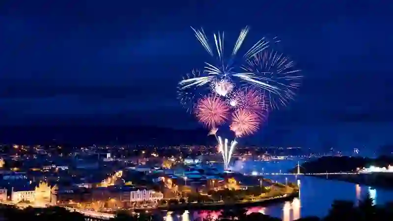 Fireworks light up the River Foyle during Derry Halloween celebrations at night.