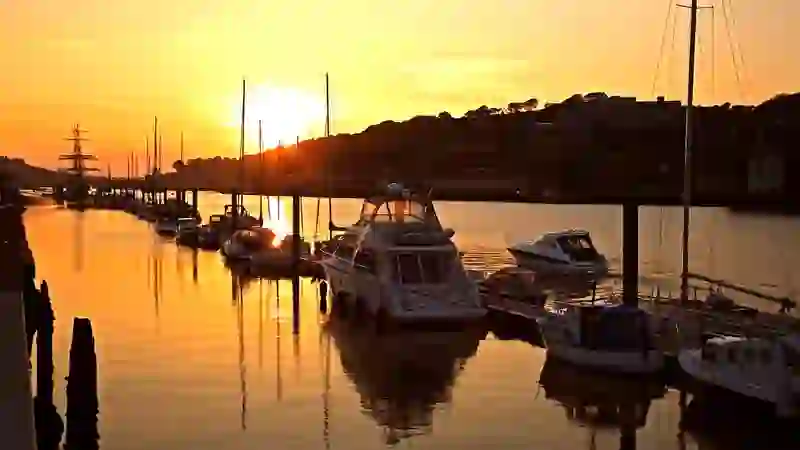 Boats moored along the River Suir in Waterford City at sunset with golden reflections on the water.