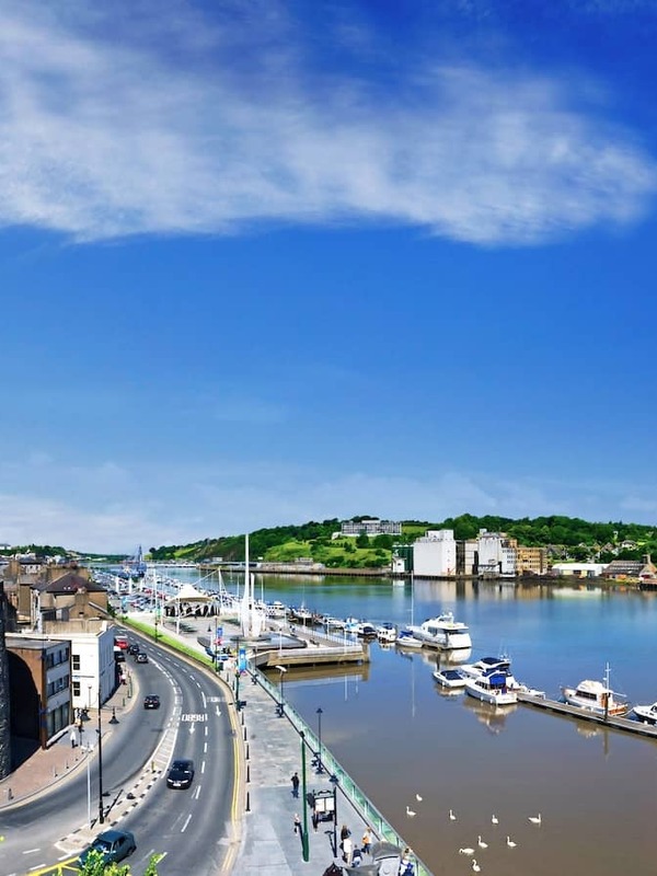 Aerial view of Reginald’s Tower and Waterford marina beside the River Suir on a bright summer day.