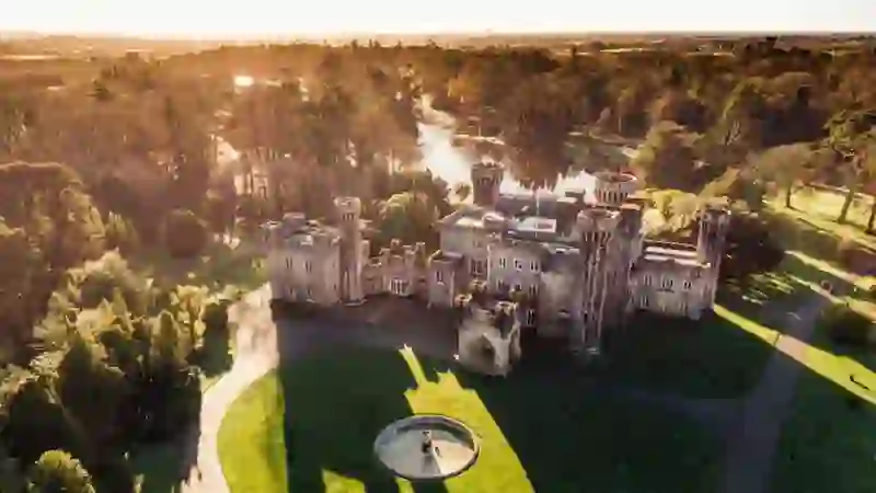 Aerial view of Johnstown Castle in County Wexford surrounded by woodland, lakes and landscaped gardens.