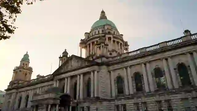 Das Rathaus von Belfast im Herzen der Stadt, stimmungsvoll in der Abenddämmerung beleuchtet, mit seiner beeindruckenden Kuppel und neoklassischen Architektur.