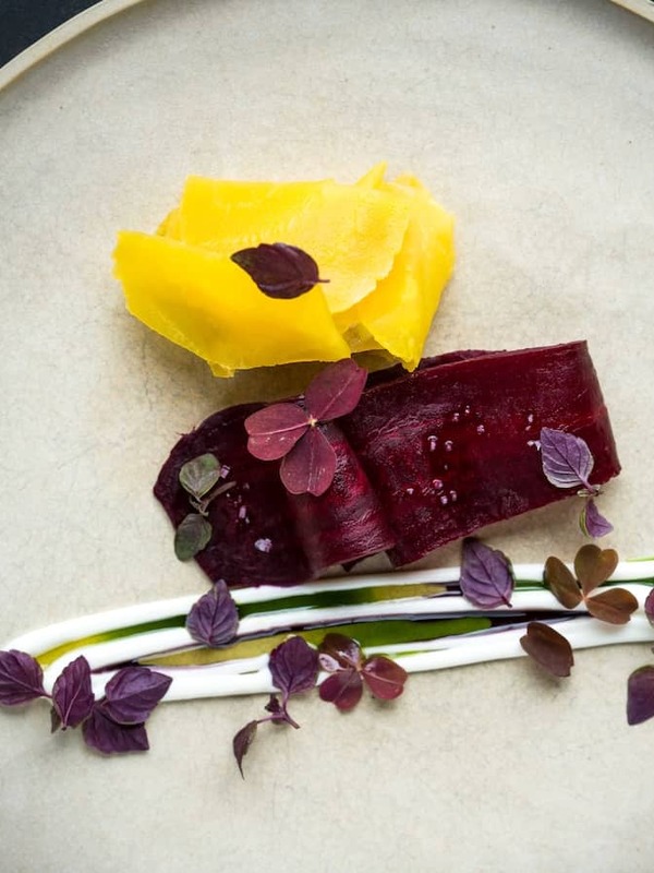 Modern fine dining dish with beetroot, pickled vegetables and herbs plated at OX restaurant in Belfast.