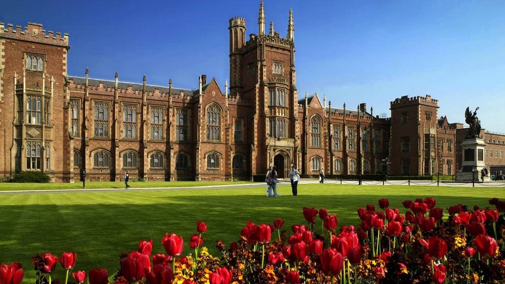 Queen’s University Belfast with red tulips in bloom on the lawn in spring sunshine.