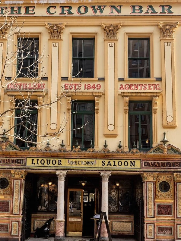 The ornate façade of the Crown Liquor Saloon in Belfast, with colourful Victorian tiles and carved detailing.