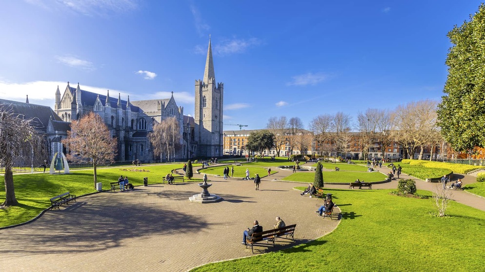People relaxing in St Patrick’s Park with St Patrick’s Cathedral in the background, Dublin.