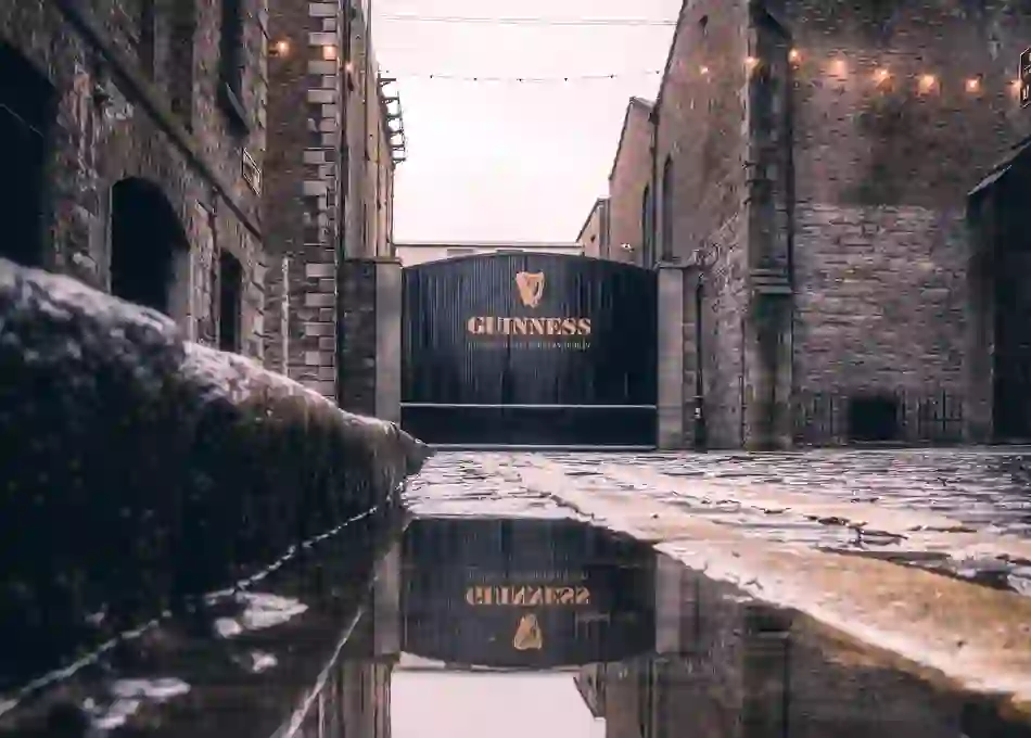 Historic Guinness gate at St James’s Gate Brewery, Dublin, with cobbled stones and soft string lights.