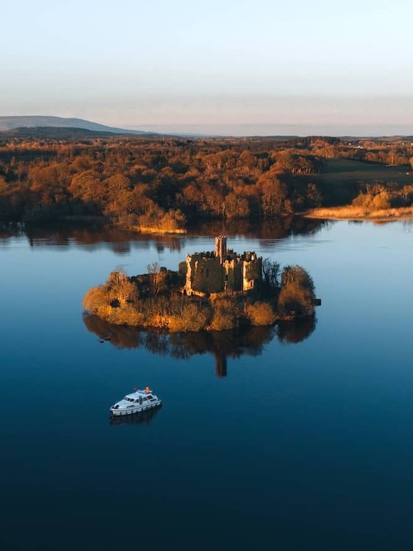 McDermott’s Castle on a small island in Lough Key surrounded by still waters at golden hour, County Roscommon.
