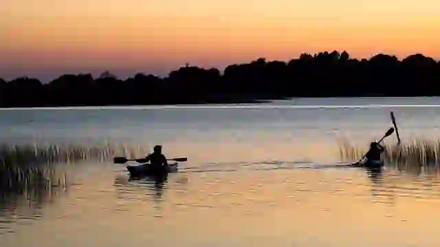 Kajakfahrer paddeln bei Sonnenuntergang auf einem ruhigen See in der Nähe von Glasson, Grafschaft Westmeath.
