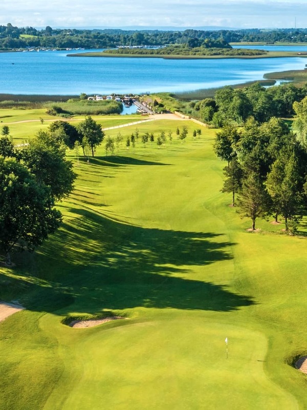 Vue aérienne du parcours de golf de Glasson Lakehouse, à Westmeath, avec des fairways verts à côté des eaux bleues de Lough Ree.