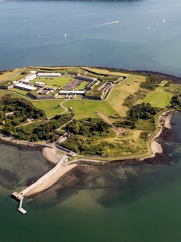 Spike Island in Cork Harbour with historic fort buildings and a pier, viewed from above.