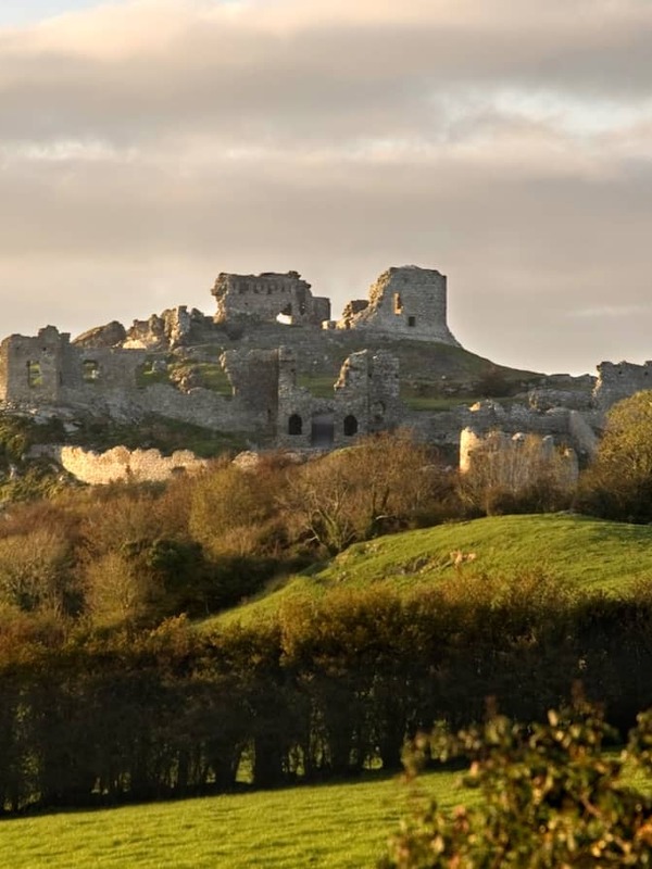 Ruins of the Rock of Dunamase on a hilltop above green countryside in County Laois.