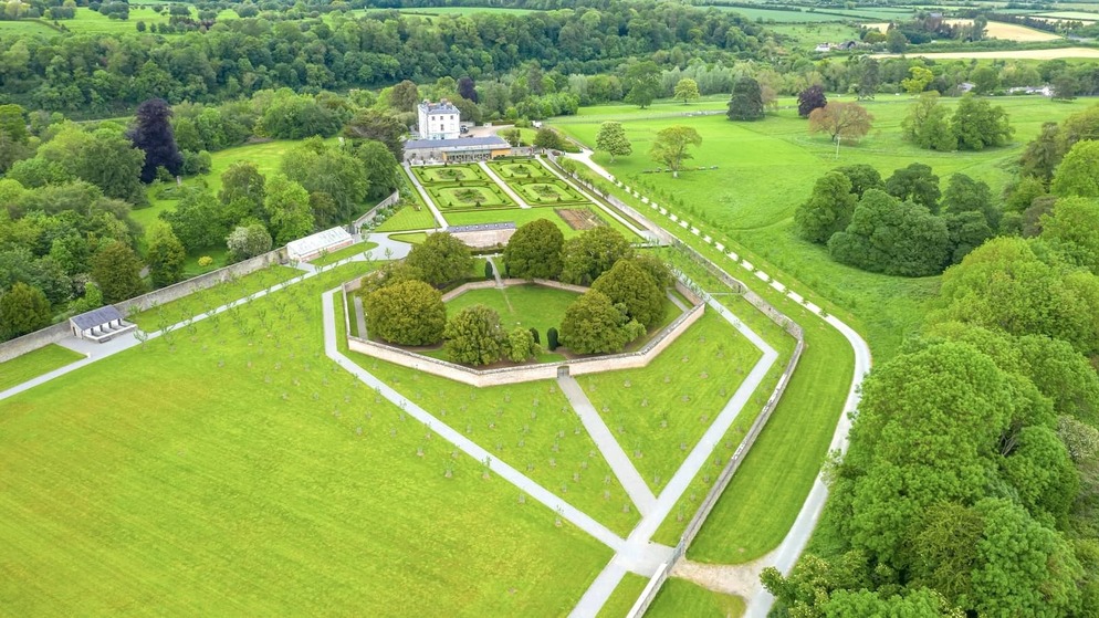 Aerial view of Oldbridge House and the Battle of the Boyne visitor centre with formal walled gardens, surrounded by lush green parkland in County Meath.