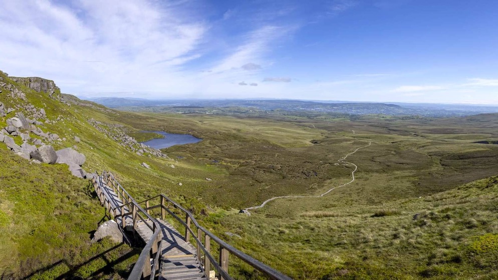 Wooden boardwalk trail winding through the Cuilcagh Mountain uplands with panoramic views across County Fermanagh.