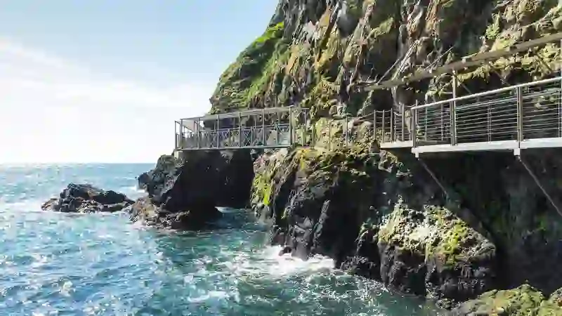 The dramatic Gobbins Cliff Path walkway clinging to sea cliffs above crashing waves on the Antrim coast.