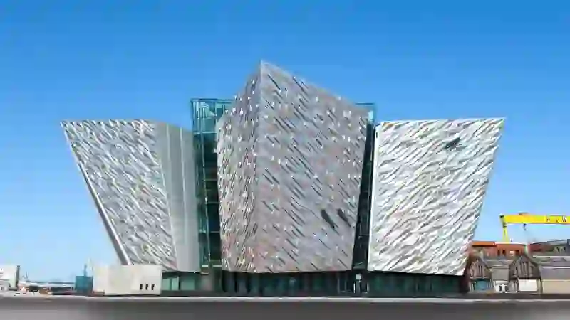 Titanic Belfast’s striking aluminium-clad facade shaped like ship hulls under a clear blue sky in the Titanic Quarter.