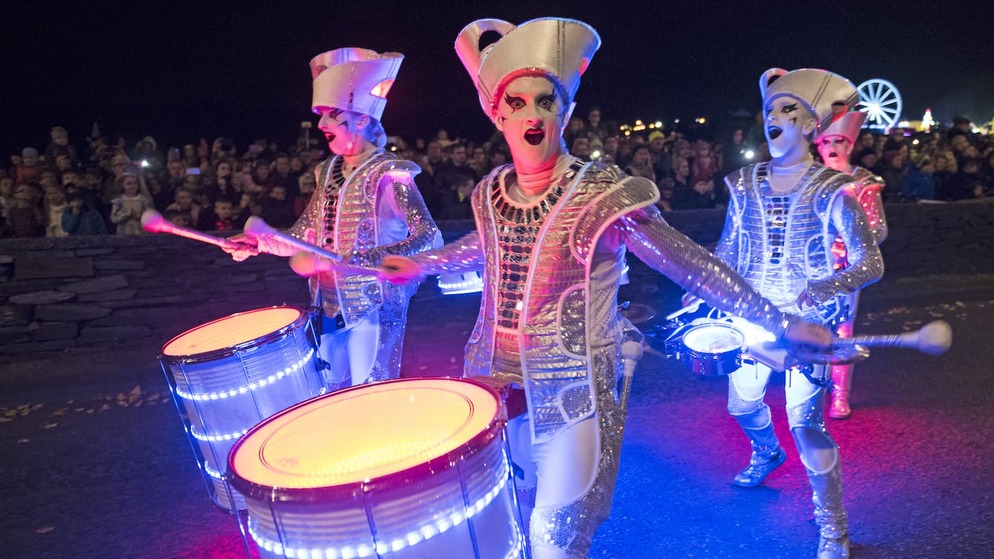 Straßentrommler in silbernen Kostümen unterhalten die Zuschauer bei der Halloween-Nachtparade in Derry.