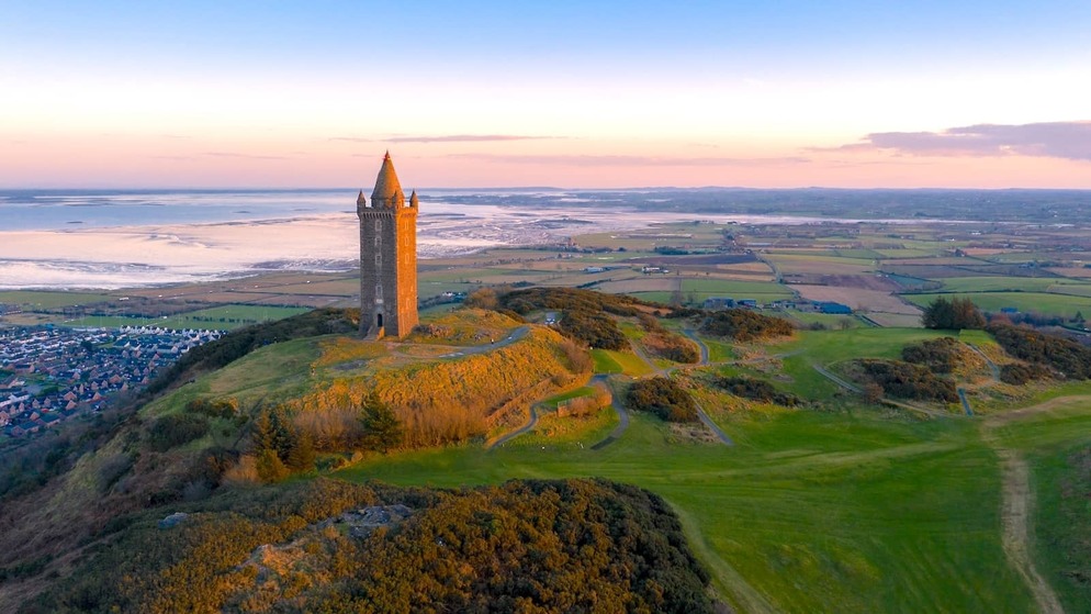 Scrabo Tower overlooking rolling hills and Strangford Lough at sunset near Newtownards, County Down.