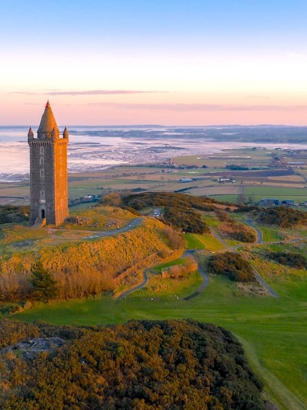 Scrabo Tower overlooking rolling hills and Strangford Lough at sunset near Newtownards, County Down.