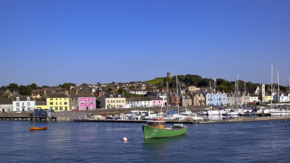 Colourful houses line the harbour in Portaferry, Northern Ireland, with yachts moored by the quay.
