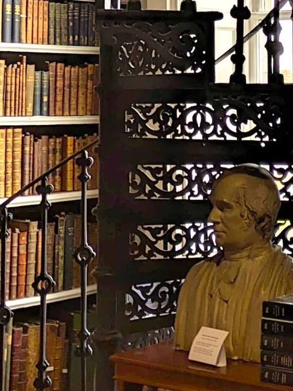 Bust, spiral staircase and shelves of antique books in the historic Robinson Library, Armagh.