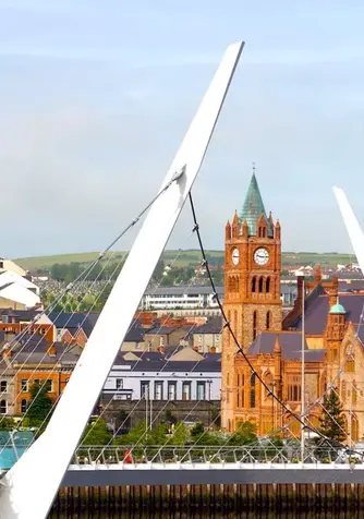 Die Friedensbrücke, die sich über den Fluss Foyle schmiegt, mit dem Rathaus von Derry~Londonderry im Hintergrund, Nordirland.