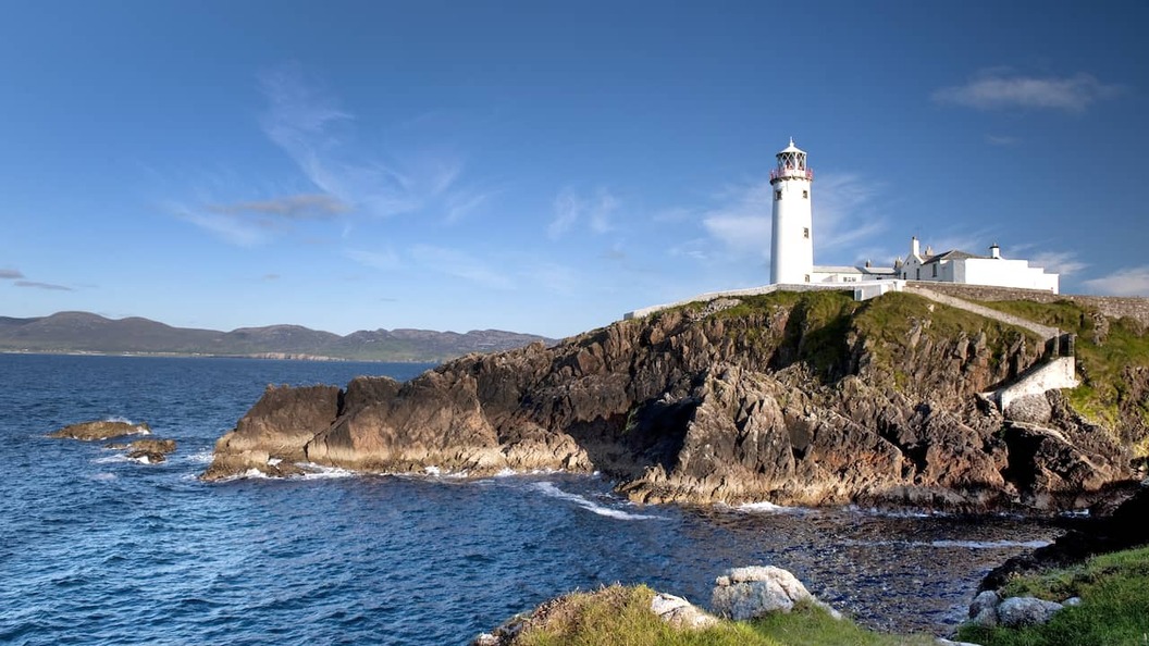 Le phare de Fanad Head surplombant les falaises escarpées et la côte atlantique du comté de Donegal par une journée claire.