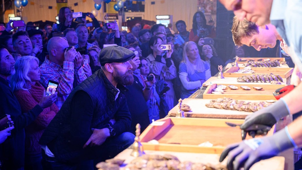 Excited crowd watches an oyster shucking competition at the Galway International Oyster Festival.