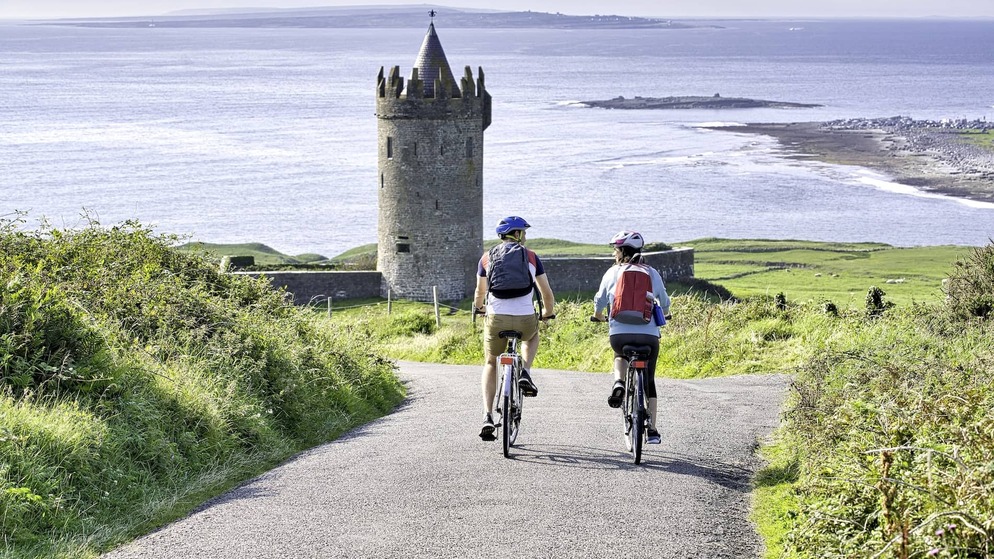 Panoramic view of winding coastal road through green hills overlooking the Atlantic Ocean on the Wild Atlantic Way.