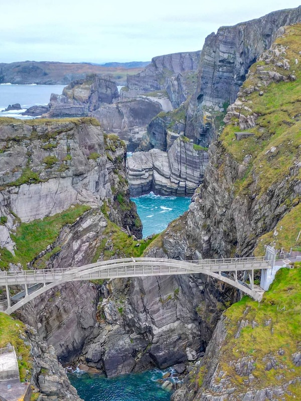 Aerial view of the dramatic Mizen Head cliffs with a pedestrian bridge spanning a deep sea gorge along the Wild Atlantic Way.