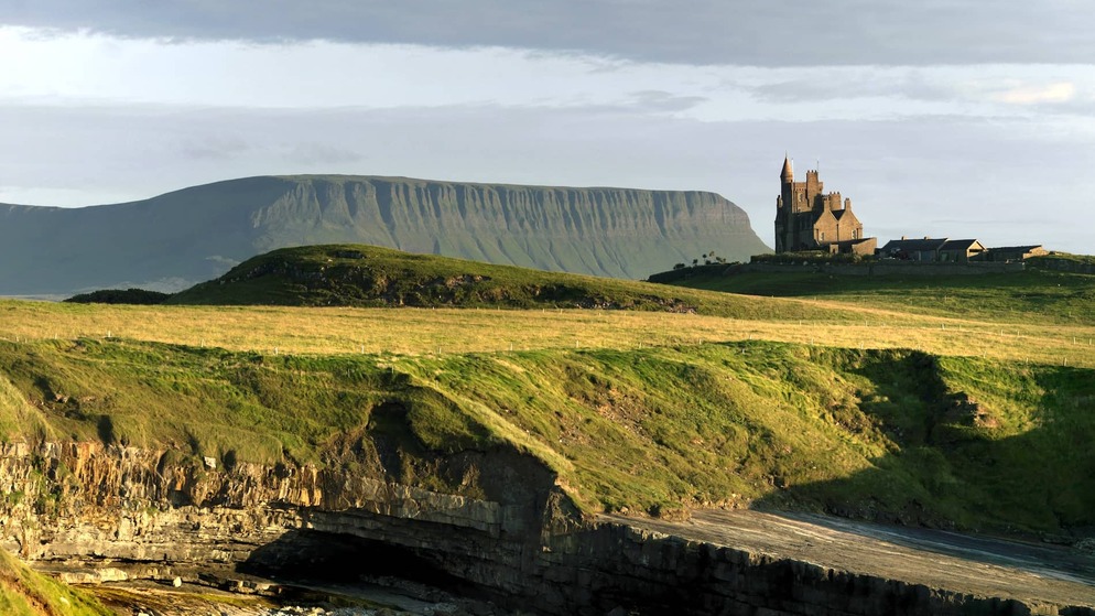 Castle on a grassy hill beneath the Dartry Mountains near Mullaghmore Head, County Sligo.