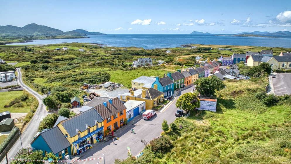 Aerial view of rainbow-painted houses lining a village street in Eyeries, on Cork's Beara Peninsula coast.