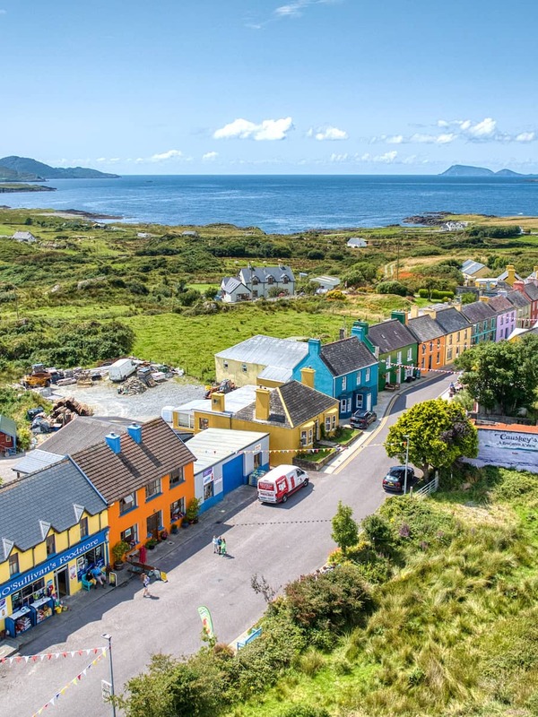 Aerial view of rainbow-painted houses lining a village street in Eyeries, on Cork's Beara Peninsula coast.