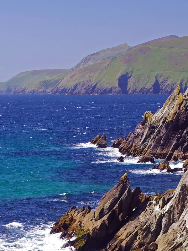 Rocky cliffs meet crashing waves and deep blue Atlantic on the wild coastline of the Ring of Kerry.