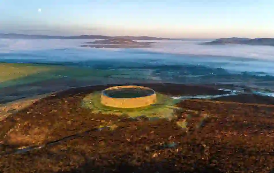 Ancient stone ring fort on a hilltop overlooking misty valleys and distant hills in Inishowen, County Donegal.