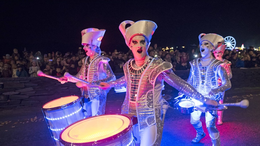 Straßenkünstler in silbernen Kostümen spielen während der Halloween-Feierlichkeiten in Derry~Londonderry auf Trommeln.