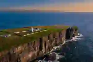 A cliff and Irish coastline by sunset