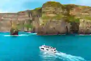 a boat in front of the Cliffs of Moher