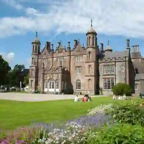 Tourists exploring the gardens and historic Gothic architecture of Glenarm Castle in County Antrim.