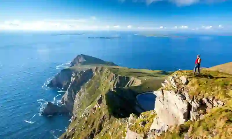 Hiker overlooking Croaghaun Cliffs and Atlantic Ocean on Achill Island, County Mayo, Ireland.
