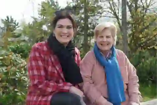 Sandi Toksvig and CS Lewis expert Lolly Spence, smiling together outdoors at CS Lewis Square in Belfast.