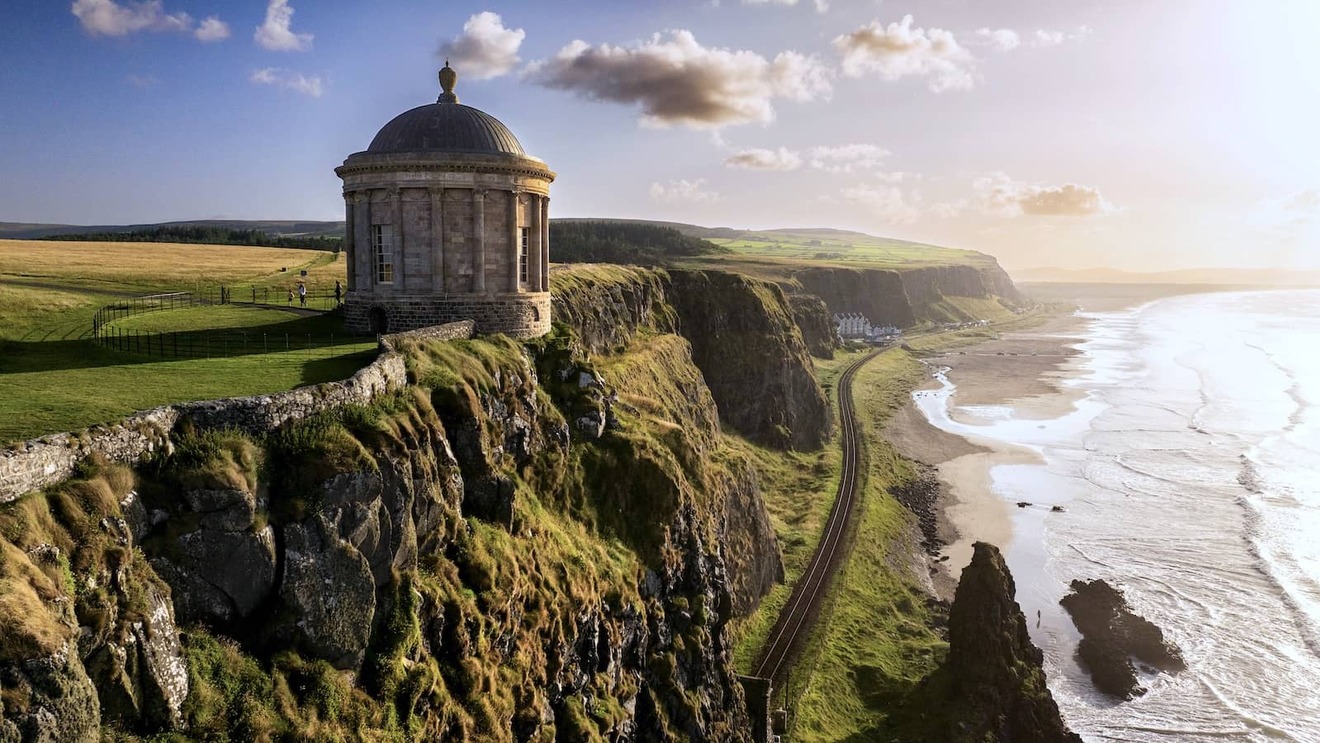 Der Mussenden Temple thront auf einer Klippe über einem endlosen Strand, während die Bahnlinie die Küste der Grafschaft Londonderry säumt.