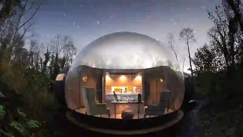Bubble dome glows beneath a starry sky at Finn Lough forest retreat, County Fermanagh.