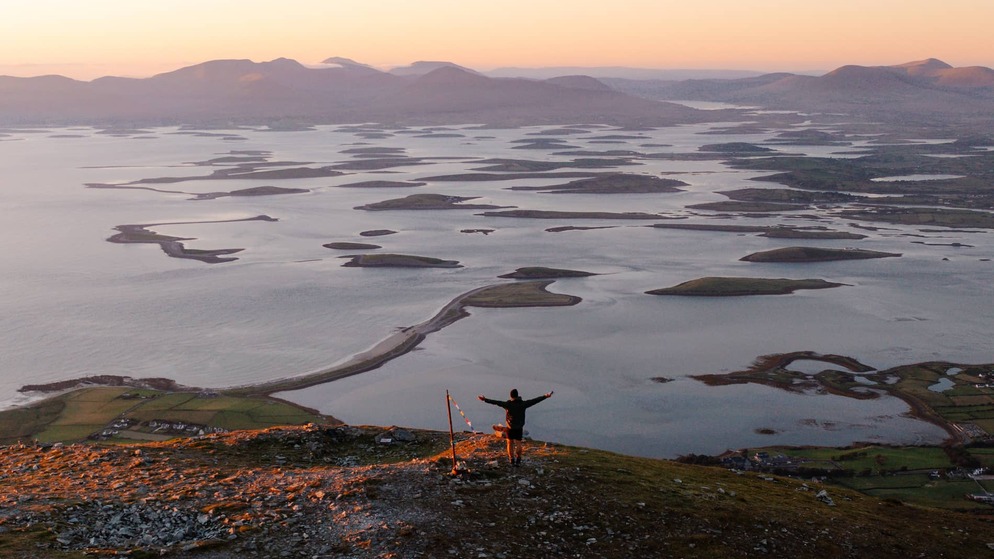 Sunset over Clew Bay in County Mayo, with scattered islands stretching across calm coastal waters.