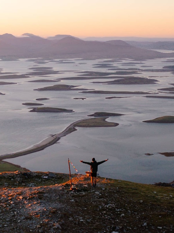 Sunset over Clew Bay in County Mayo, with scattered islands stretching across calm coastal waters.