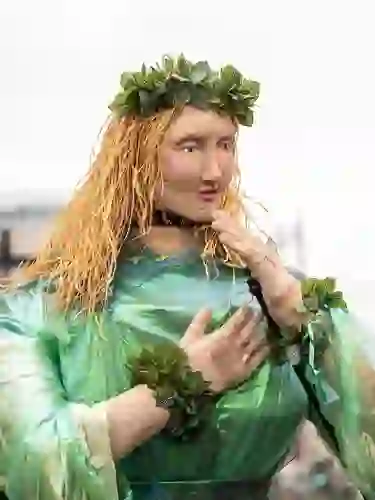 Green-clad puppet figure with leafy crown and woven features at a St Patrick’s Day parade in Dublin.