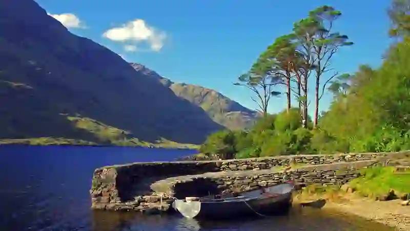Panoramic view of the Doolough Valley in County Mayo with mountains, fields and the Atlantic coastline beyond.