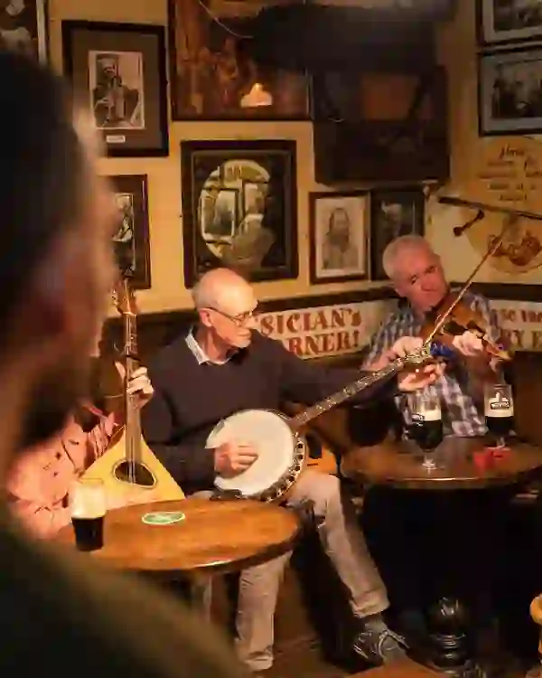 Traditional Irish music session with musicians playing fiddle and banjo in Matt Molloy's pub, Westport, County Mayo.